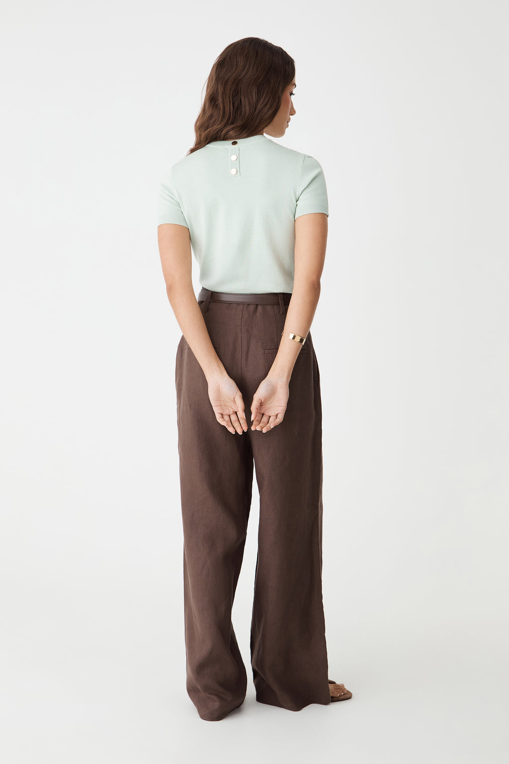 Back view showing the jade knit top with gold-tone button at the back neck