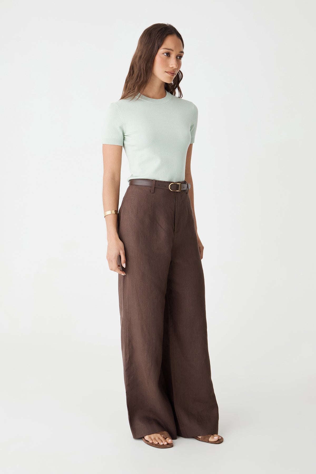 Side view of the jade Catherine Short Sleeve Knit with brown trousers