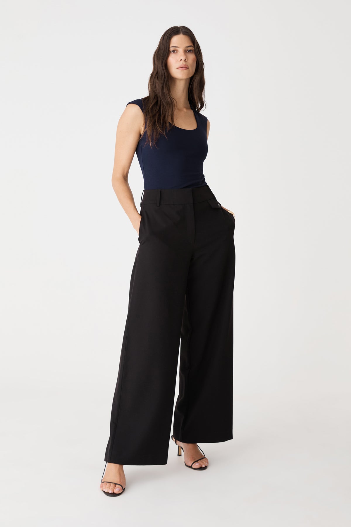 Front view of the dark navy top tucked into black wide-leg trousers