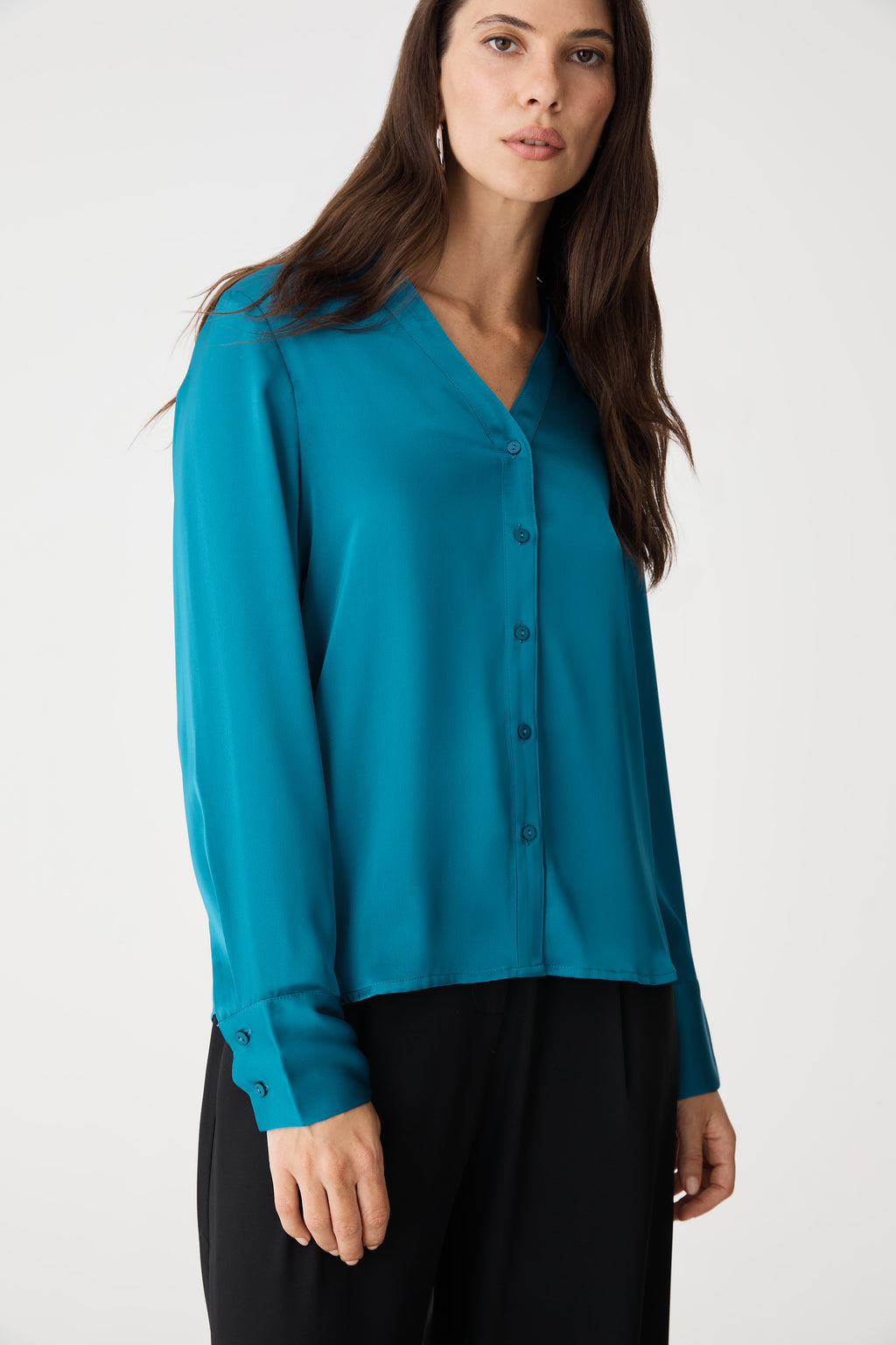 Close-up of the aquamarine satin blouse, buttons and cuffed sleeve