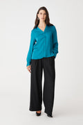 Lila V-Neck Satin Blouse in aquamarine, front view worn with black wide-leg trousers