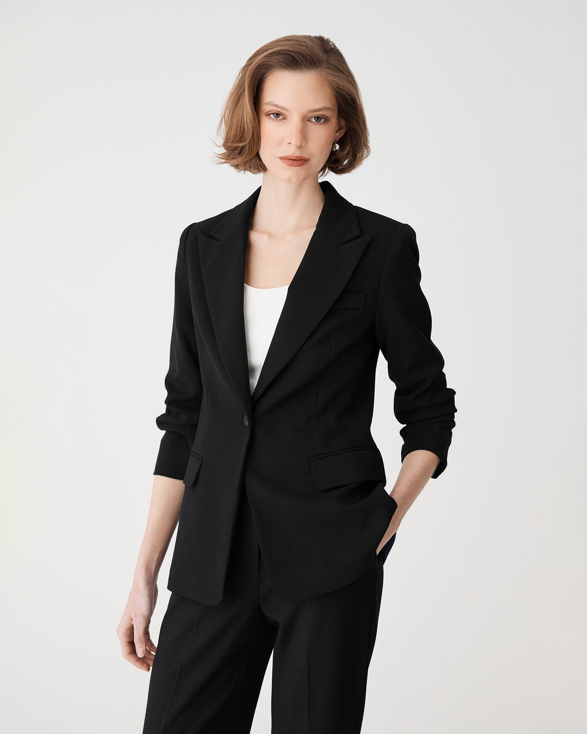 Front view, blazer buttoned with peak lapels and white top underneath