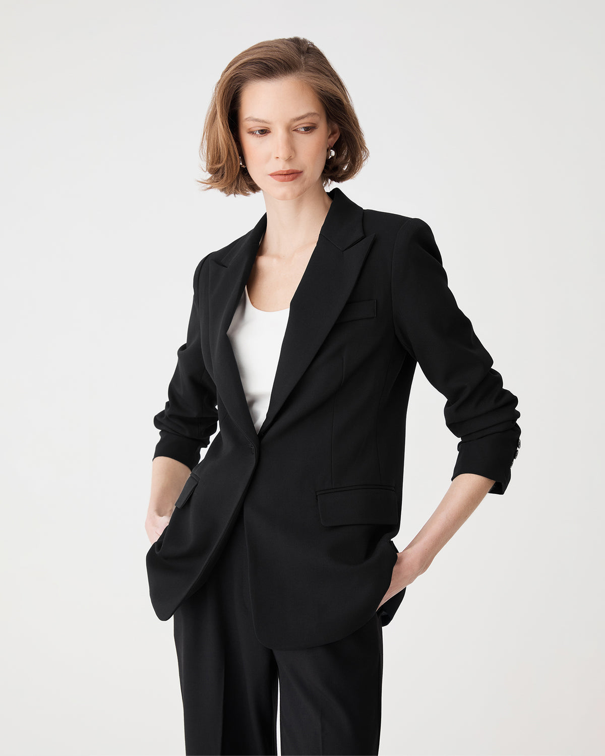 Close front view of the black blazer's peak lapel collar and single button fastening