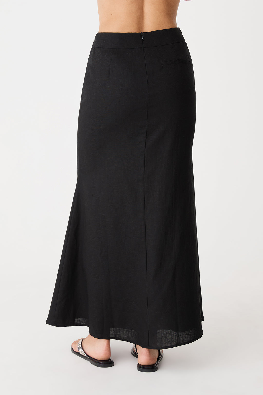 Back view of the black maxi skirt showing invisible back zipper and flared hem