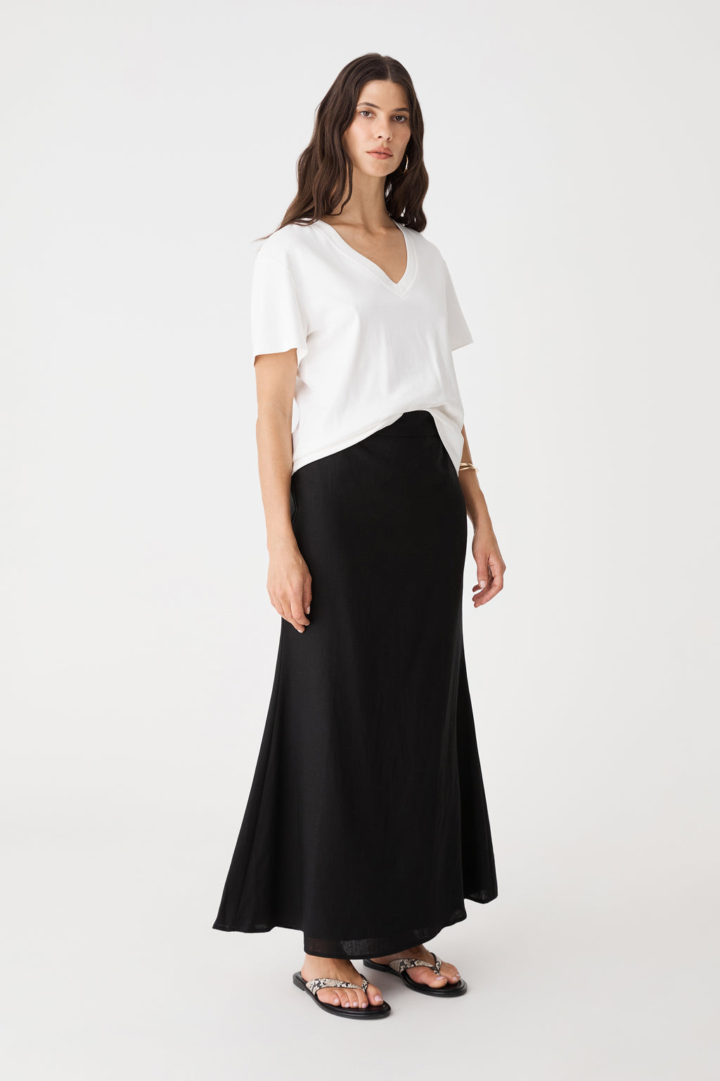 Side view of the black Amelia Linen Blend Maxi Skirt with white tee and black sandals