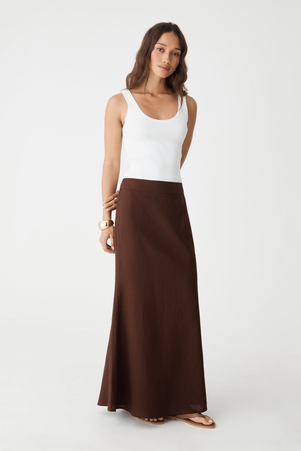 Front view of the chocolate maxi skirt worn with a white tank top