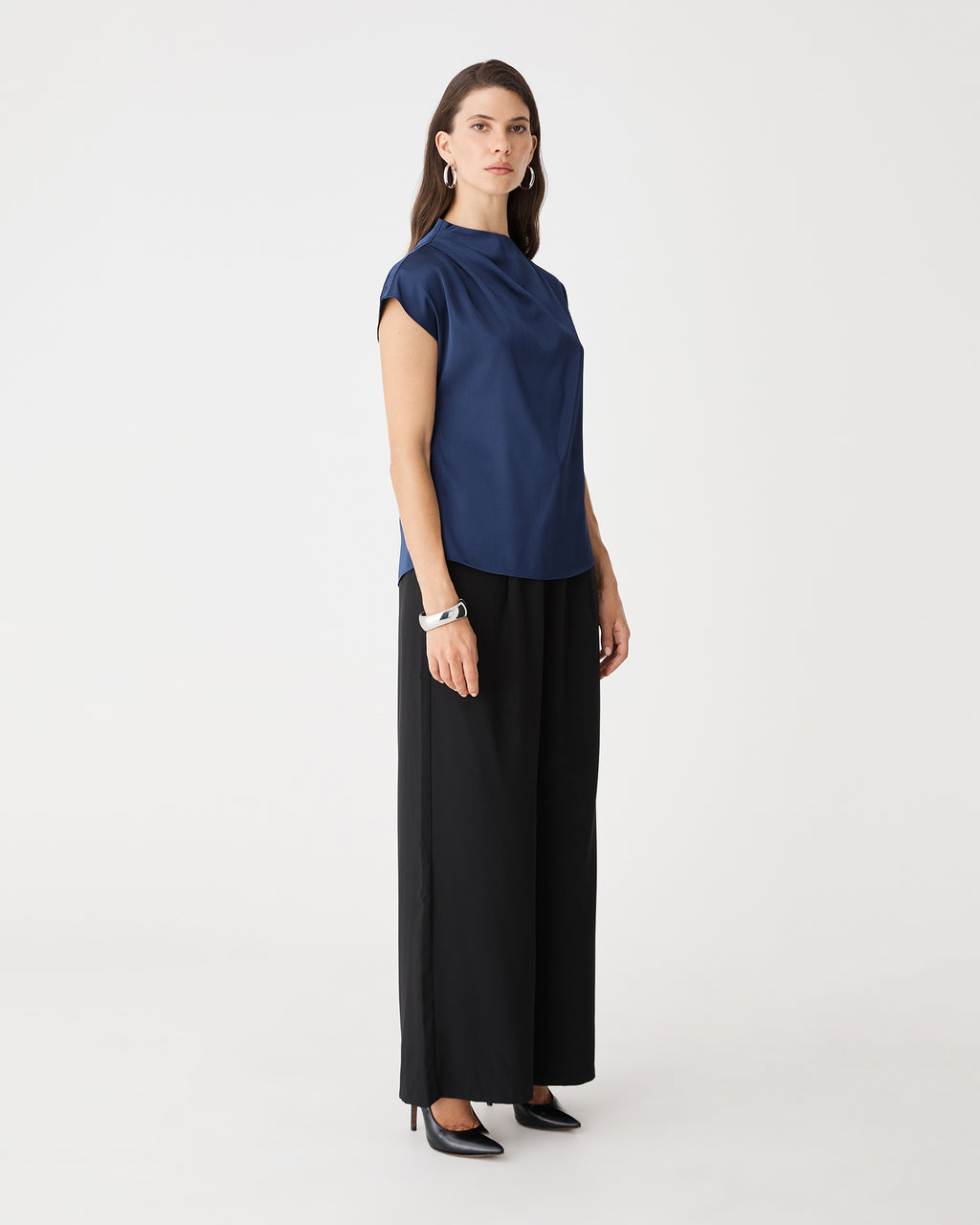 Side view of the navy Zafina Pleated Draped Top with black trousers