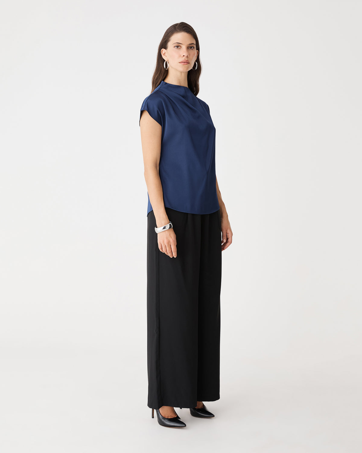 Side view of the navy Zafina Pleated Draped Top with black trousers