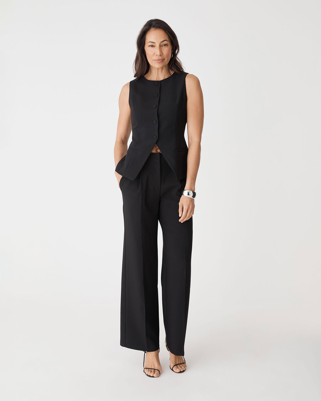 Front view of black Nikki Longline Vest worn with matching wide leg pants