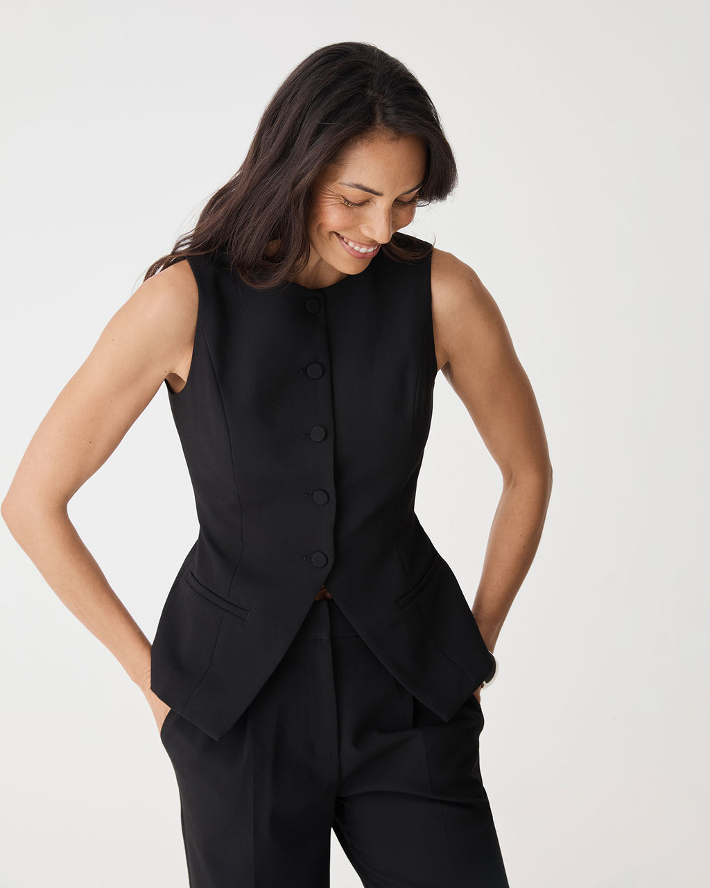 Close-up of black Nikki Longline Vest front buttons and welt pockets