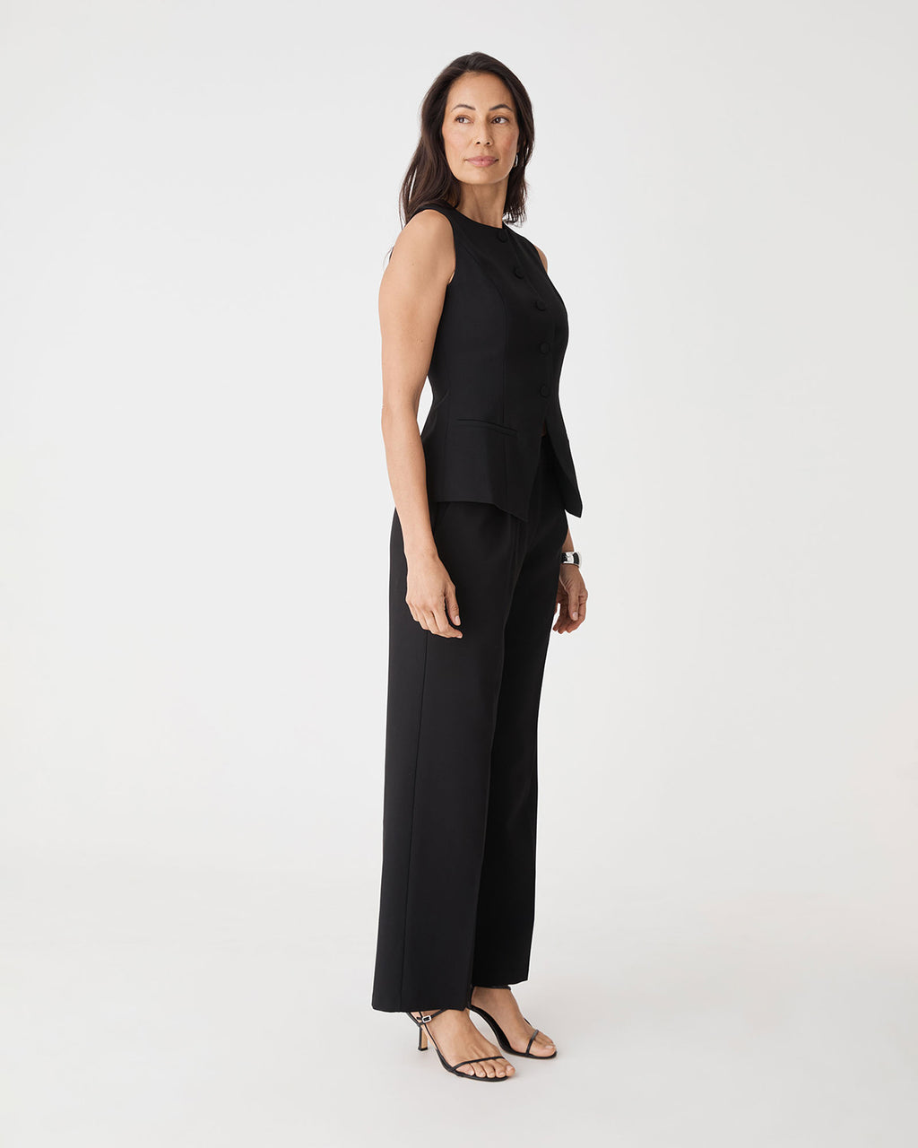 Side view of the black Nikki Longline Vest with matching wide leg pants