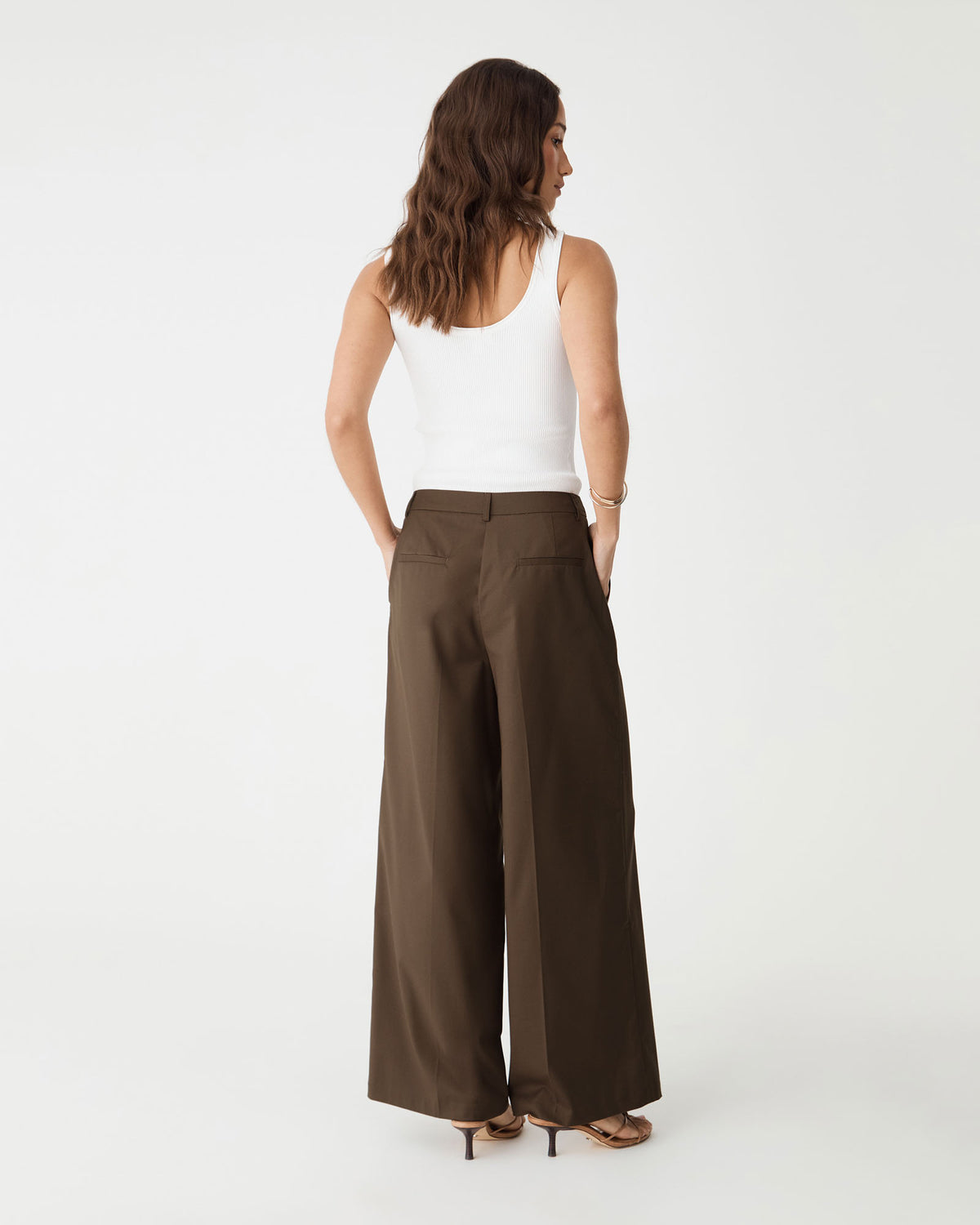 Back view showing faux welt pockets and waist darts on the cocoa brown wide leg pants