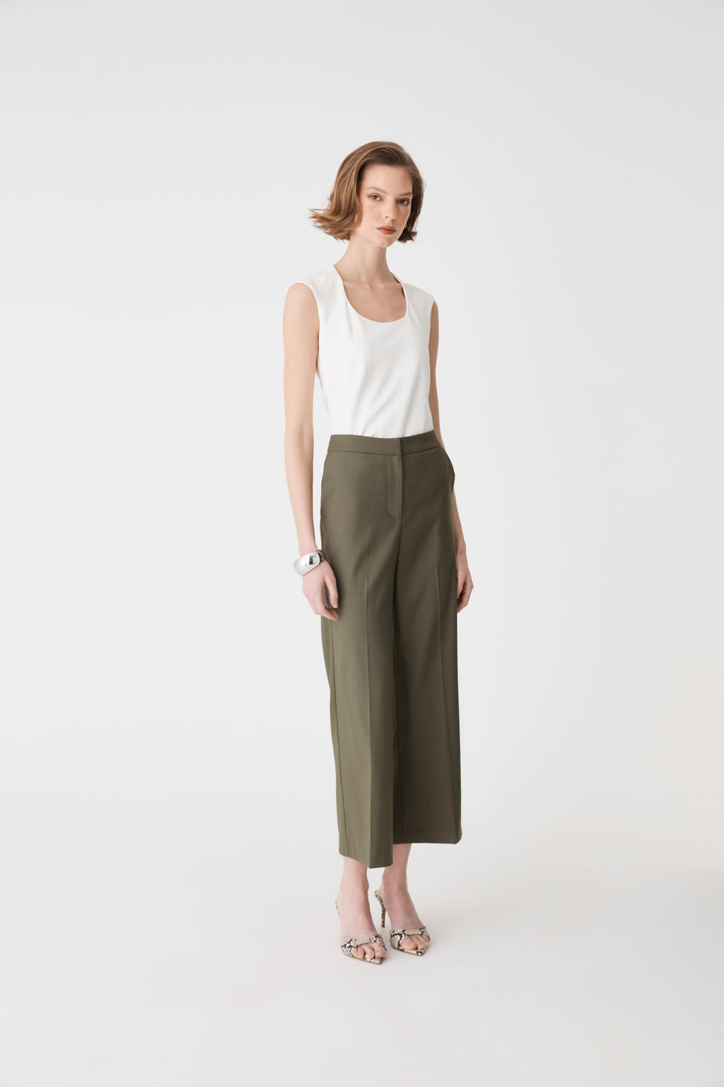 Side-angle full-length view of olive Milan Crop Flare Pants with white top
