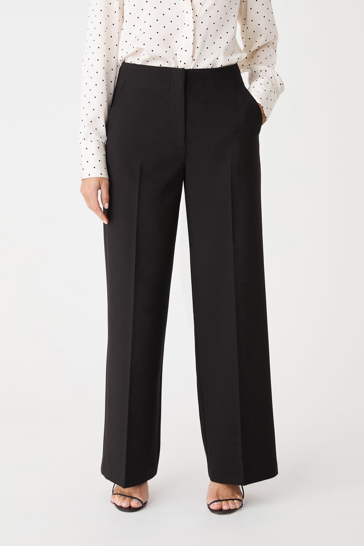 Close-up front view of the black pants showing the waistband and front pleats