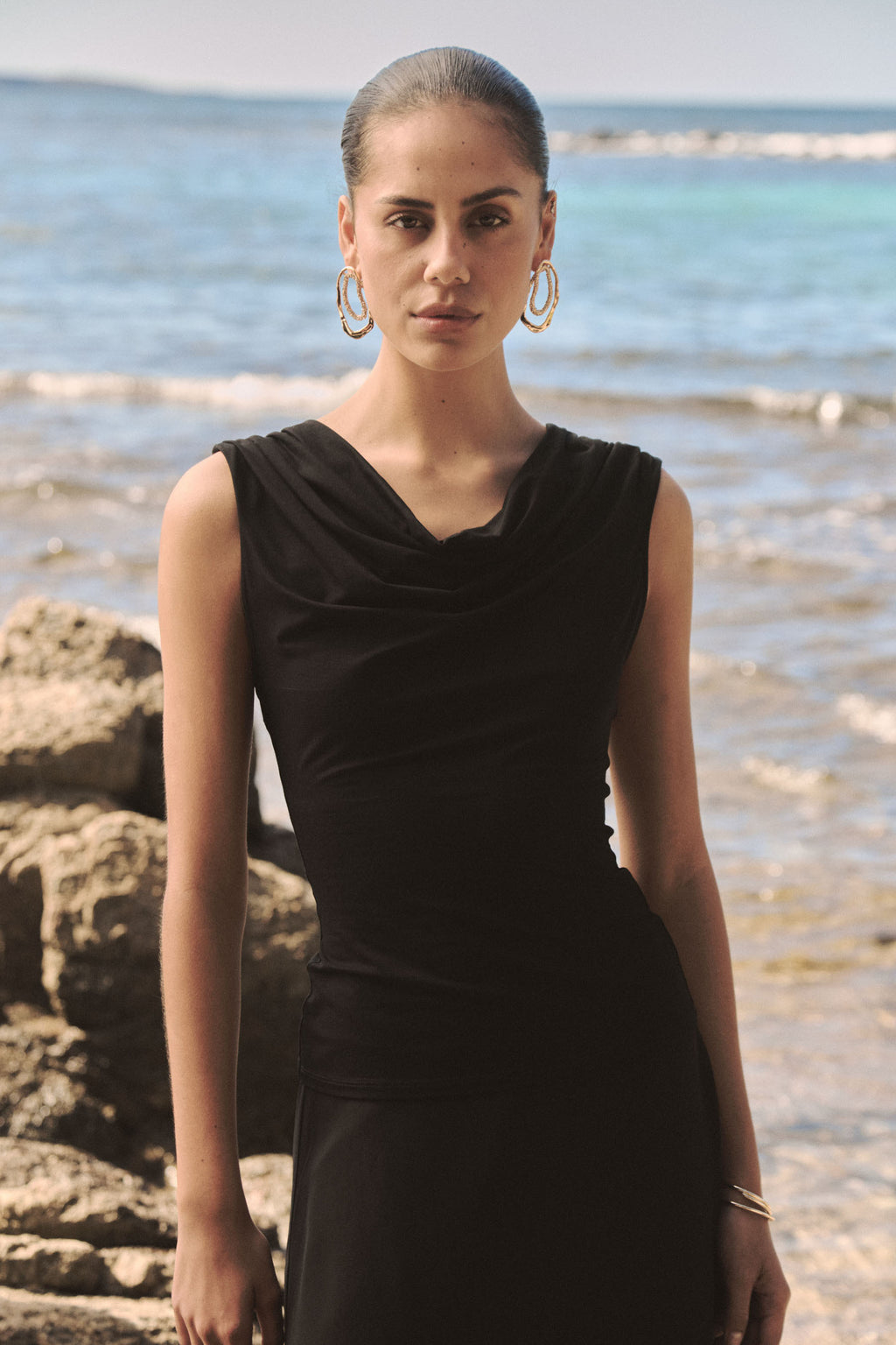 Close-up of the draped cowl neckline and shoulder ruching in black