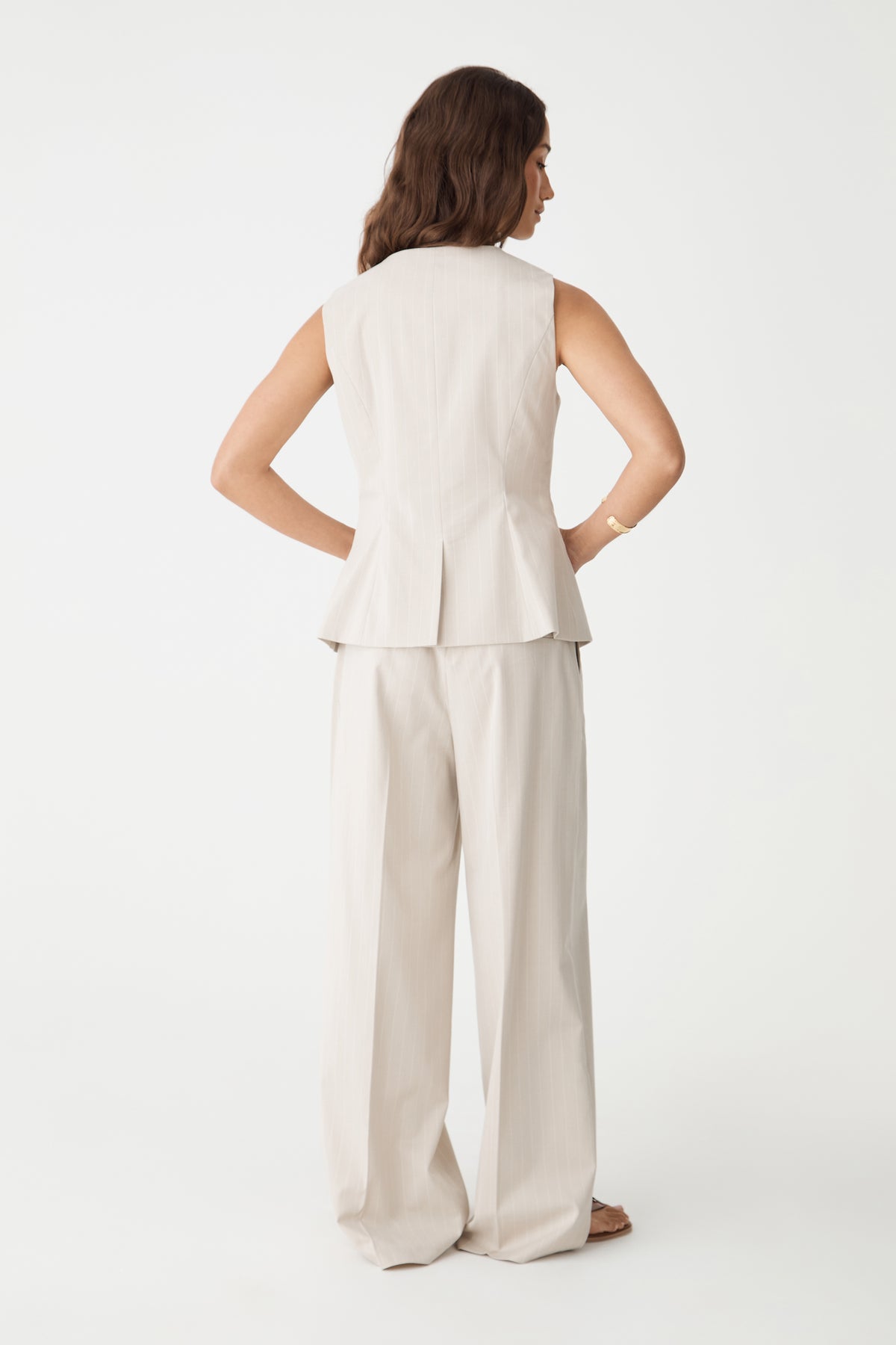 Back view of the beige pinstripe vest, close-up of the fitted waist