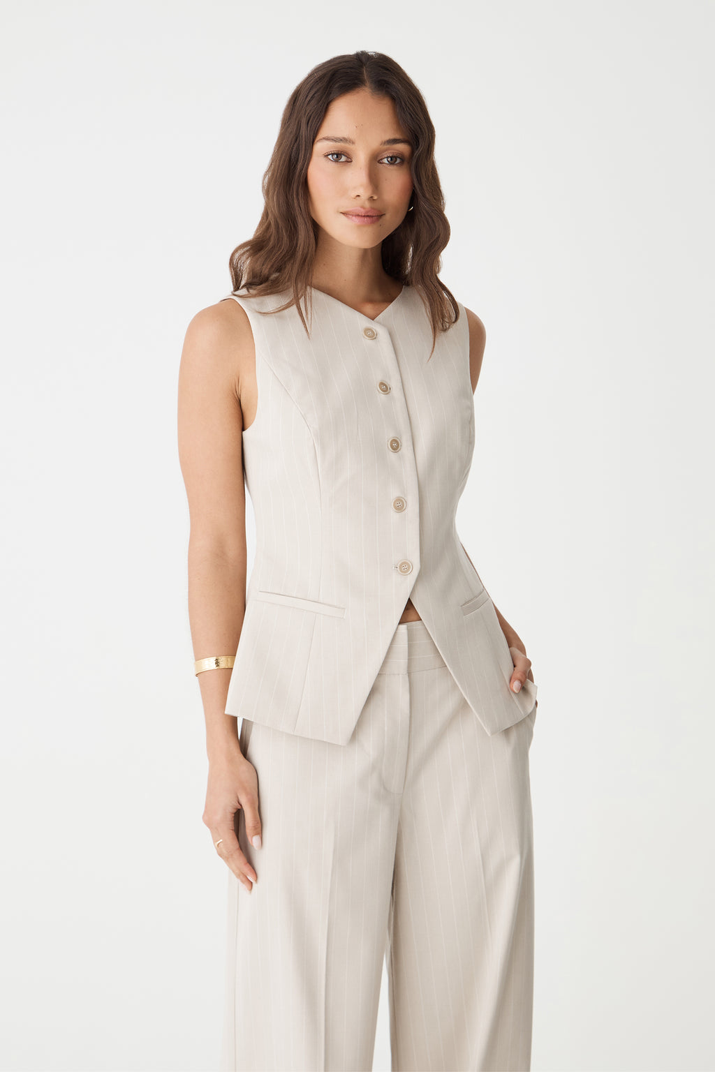 Close-up front view of the beige pinstripe vest showing V-neckline, button front and welt pockets