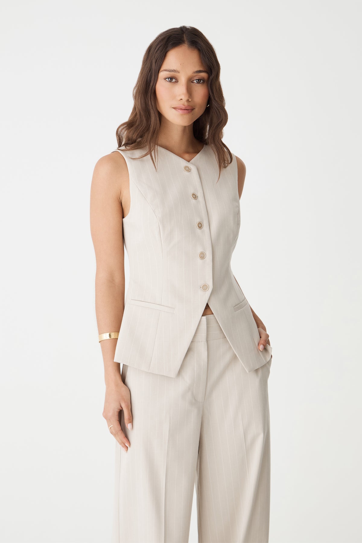 Close-up front view of the beige pinstripe vest showing V-neckline, button front and welt pockets