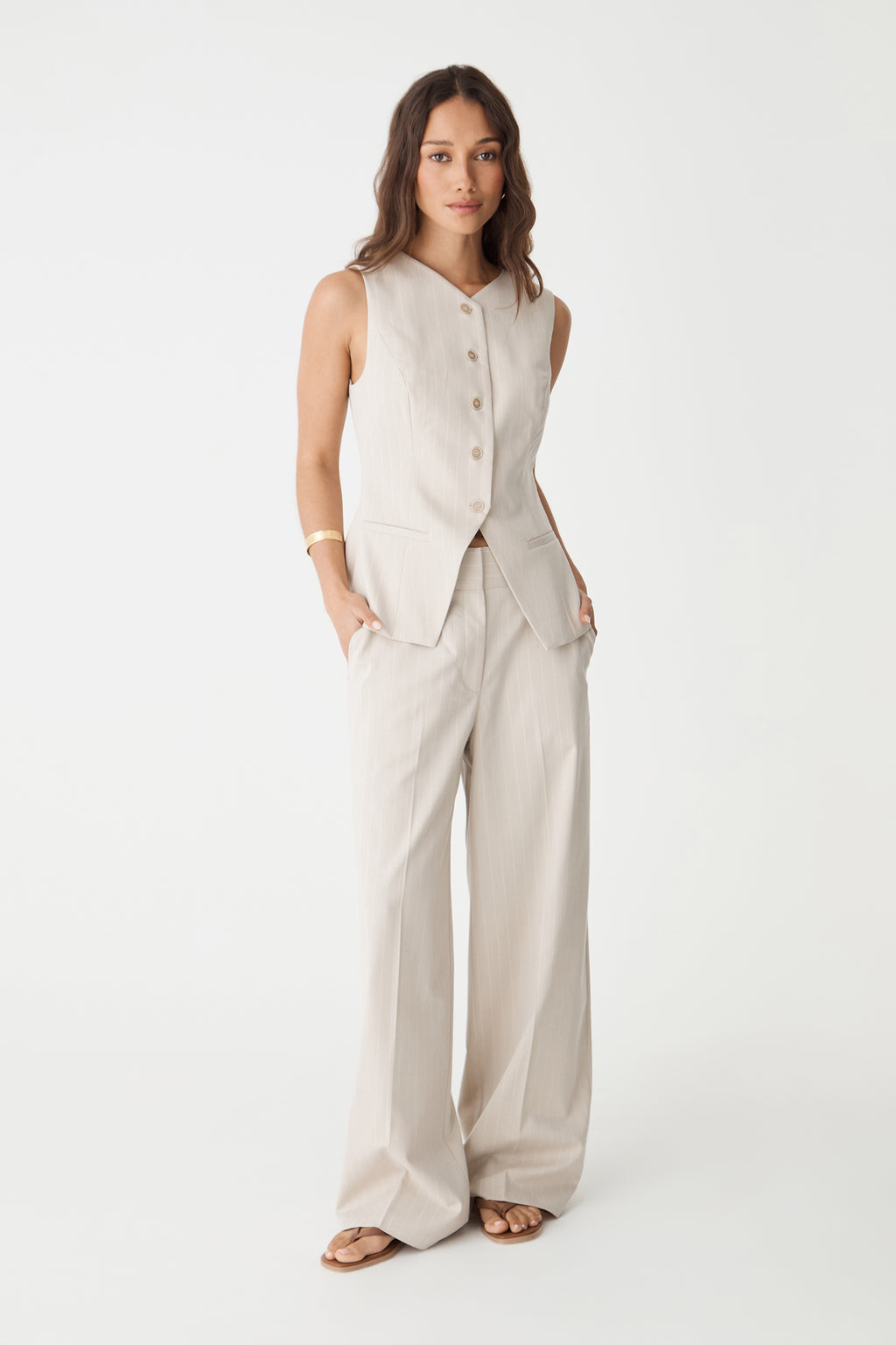 Front view of the beige pinstripe vest showing the inverted V-shaped hem