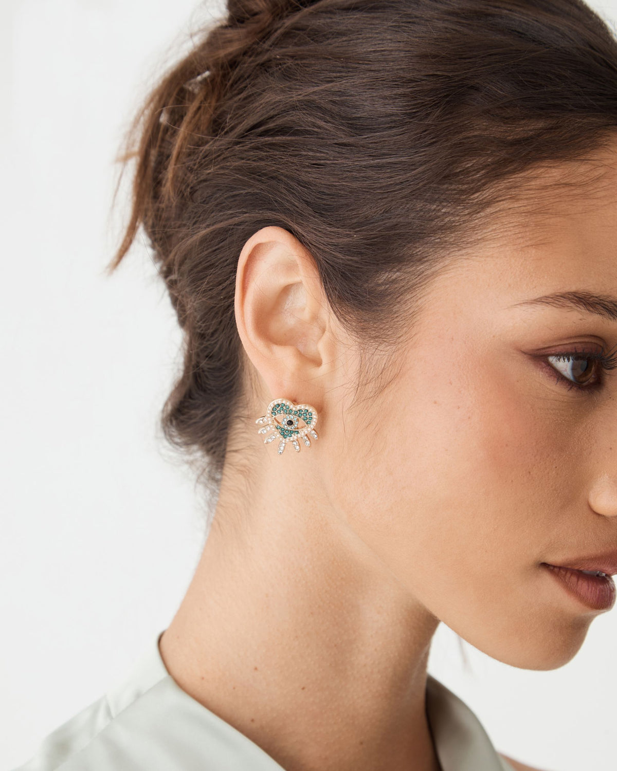 Side view of Betty Heart Eye Earrings worn on ear, hair tied back